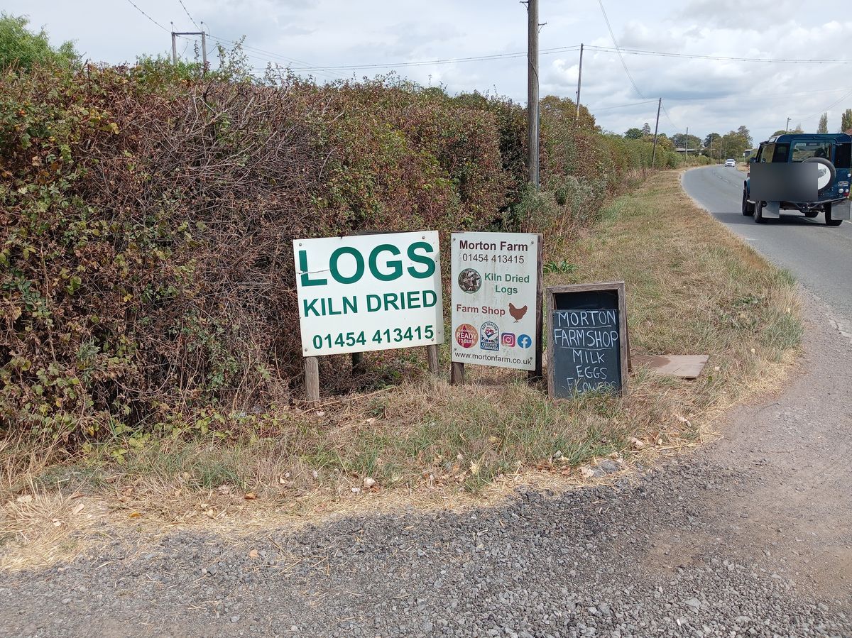 Roadside signs for Morton Farm on Old Gloucester Road, with the farm landline number on them